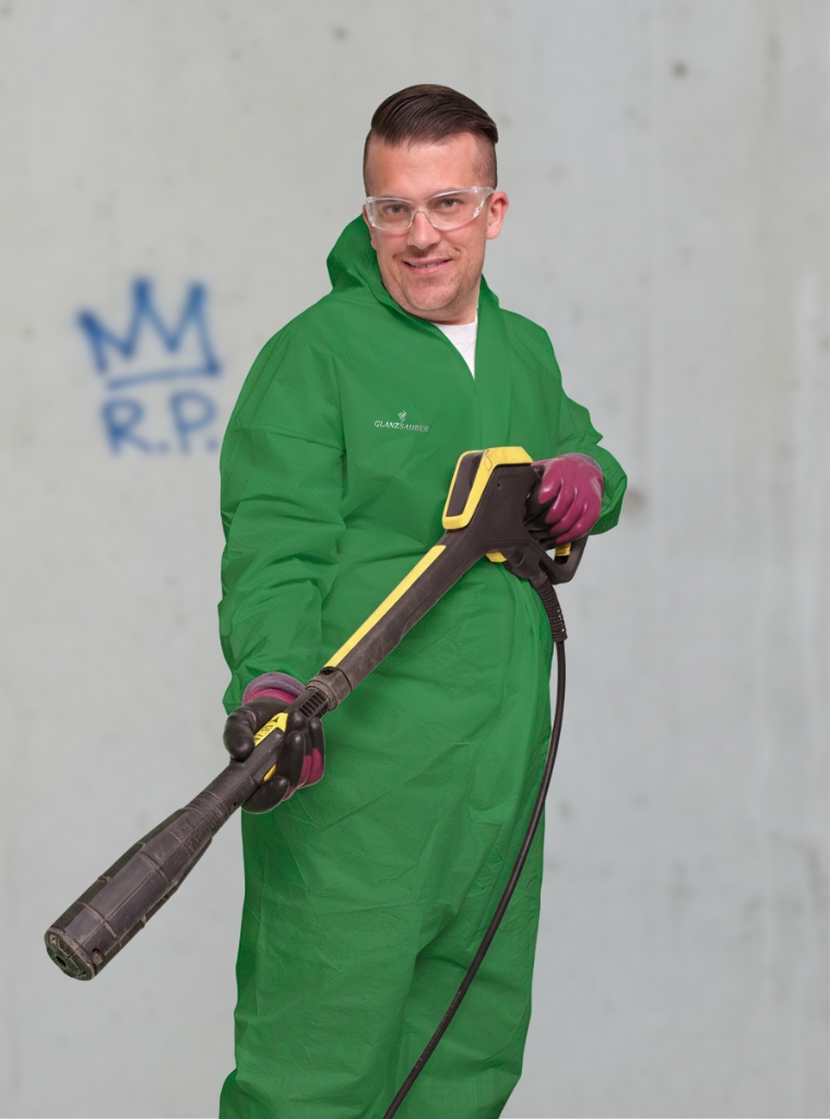 Eine Reinigungskraft der GlanzSauber Gebäudereinigung bei einer Graffitientfernung